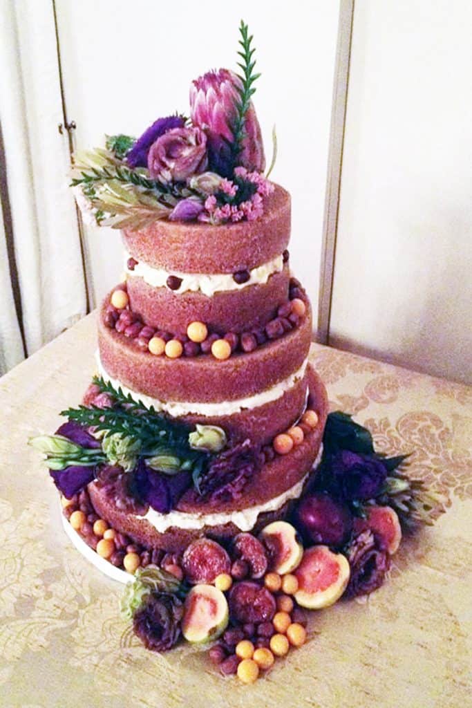 Rustic naked chocolate wedding cake with proteas and fruit in Howick KZN Midlands